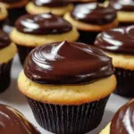 Delicious Boston Cream Cupcakes topped with chocolate and creamy filling