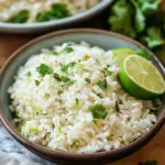 Bowl of cilantro lime rice with fresh cilantro and lime wedges