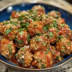Bowl of easy turkey meatballs without breadcrumbs, garnished with herbs.