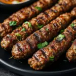 Delicious Middle Eastern kofta kebabs on a plate, garnished with fresh herbs.