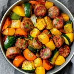 Sheet pan with sausage and mixed veggies, perfect for a quick weeknight meal.