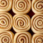 Delicious bread machine cinnamon rolls topped with creamy frosting.