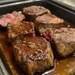 Delicious deer steaks cooking in the oven for a savory meal.