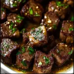 Juicy garlic butter steak bites served on a plate with herbs
