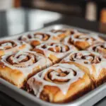 Delicious overnight sourdough cinnamon rolls topped with cream cheese icing.