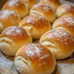 Freshly baked sourdough rolls on a wooden table
