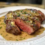 Venison backstrap served with garlic butter sauce on a plate