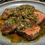 Delicious venison steak seasoned with oregano and served on a plate.