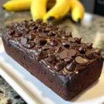 High-protein chocolate banana bread loaf on a wooden cutting board