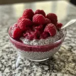 Delicious Raspberry Chia Pudding topped with fresh raspberries and drizzled with maple syrup.