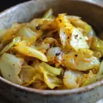 Plate of simple sautéed cabbage recipe with seasonings and herbs.