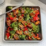 Sheet pan sticky sesame chicken with broccoli, a delicious weeknight dinner option.