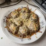 Amish Hamburger Steak Bake served on a plate with fresh vegetables