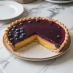Blueberry lemon curd tart garnished with fresh blueberries and lemon zest