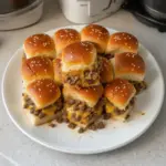 Delicious cheeseburger sliders served on a platter with pickles and condiments