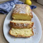 Slice of Coconut Lemon Loaf Cake with coconut flakes and lemon zest