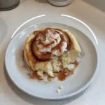 Cottage Cheese Cinnamon Roll Mug Cake topped with icing in a mug.