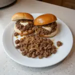 Delicious French Onion Beef Sloppy Joes served on a plate with toppings.