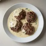 Delicious hamburger steaks served with creamy dill sauce on a plate