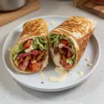 Healthy BLT wraps drizzled with secret sauce on a plate