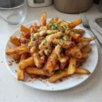 Plate of Louisiana Voodoo Fries topped with spicy seasonings and sauce
