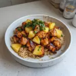 Delicious Pineapple Chicken served over rice with fresh pineapple chunks.