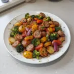 Roasted Veggie and Chicken Sausage sheet pan dinner on a baking sheet
