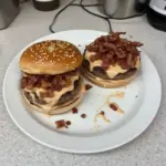 Smash burger topped with baconnaise sauce on a wooden plate
