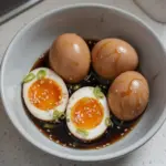 Delicious soy sauce eggs served on a plate with garnish
