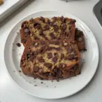 Slice of super moist chocolate chip banana bread with chocolate chips and bananas