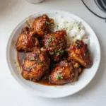 Plate of authentic Filipino Chicken Adobo served with rice and vegetables.