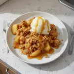 Delicious baked apple crumble topped with a crispy mixture, served warm.