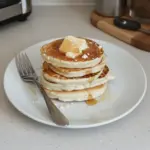 Plate of fluffy carnivore cottage cheese pancakes topped with fresh berries