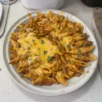 Delicious bowl of Cheesy Enchilada Hamburger Helper topped with cheese and herbs.