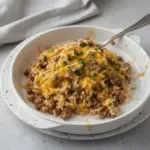 Cheesy ground beef and rice casserole in a baking dish with melted cheese