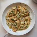 Plate of Chicken Piccata with Artichokes garnished with lemon and parsley