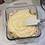 Delicious Cold No Bake Banana Pudding served in a bowl with bananas on top.