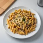 Creamy high protein beef pasta topped with fresh herbs and served in a bowl