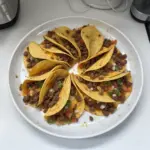 Crispy ground beef tacos with vibrant toppings served on a plate