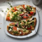 Greek Flatbread Pizza topped with olives, feta, and fresh vegetables