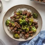 Plate of ground beef and broccoli stir-fry served with rice