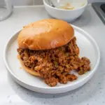 Delicious homemade sloppy joes served on a bun with toppings.