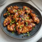 Grilled Korean chicken breasts garnished with sesame seeds and green onions