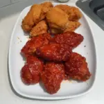 Crispy Korean Fried Chicken with a golden-brown crust served with dipping sauce.