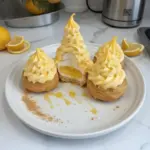 Delicious lemon cream puffs filled with citrusy lemon cream on a plate.