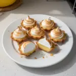 Delicious mini lemon meringue tarts topped with fluffy meringue and lemon zest.