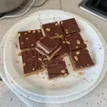 No bake chocolate peanut butter bars topped with chocolate and peanuts