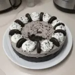 No-Bake Oreo Cheesecake topped with crushed Oreos and cream