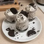 Oreo No-Bake Cheesecake Cups served in glass cups with cookie crumbles