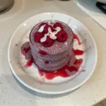 Delicious raspberry chia pudding in a glass topped with fresh raspberries